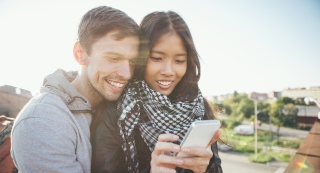 Two people looking at a smartphone