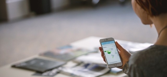 Woman looking at her smartphone displaying data for North America