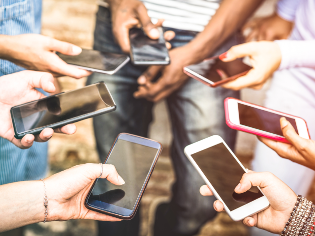 A group of people in a circle looking at their smartphones